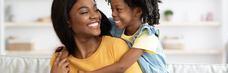 mother and daughter hugging and smiling